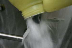 Rinsing a container over the induction hopper